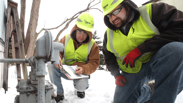 Two Ameren employees looking at gas meter. 